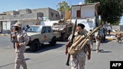 Des membres de la "Brigade 444" affiliée au ministère libyen de la Défense prennent position dans la zone d'une fusillade nocturne dans la banlieue de Tripoli, à Ain Zara, le 22 juillet 2022.