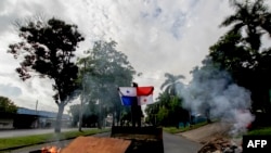 Un manifestante sostiene una bandera panameña en una avenida bloqueada durante una protesta por el alto costo de los alimentos y la gasolina en la Ciudad de Panamá, el 11 de julio de 2022.