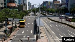 A police officer asks people to find cover during the annual 30-minute drill during which all vehicles are ordered to move to the sides of roads and pedestrians to wait in back streets in Taipei, Taiwan, July 25, 2022