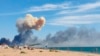 Rising smoke can be seen from the beach at Saky after explosions were heard from the direction of a Russian military airbase near Novofedorivka, Crimea, Aug. 9, 2022.