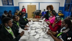 Maafisa wa uchaguzi wakihesabu kura katika kituo cha kupiga kura cha Shule ya Msingi ya Kilimera, Nairobi, Kenya, Aug. 9, 2022. 