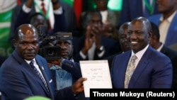 Mwenyekiti wa tume ya uchaguzi Kenya IEBC Wafula Chebukati (kushoto) akimpokeza cheti cha ushindi kwa rais mteule Dr. Willia Ruto (kulia) Agosti 15 2022. Ushindi wa Ruto umepigwa mahakamani. Picha: Reuters