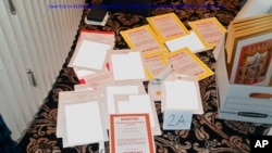 La imagen de una presentación judicial del Departamento de Justicia del 30 de agosto de 2022, redactada en parte por el FBI, muestra una foto de los documentos incautados durante la búsqueda del 8 de agosto por parte del FBI en Mar-a-Lago del expresidente Donald Trump.