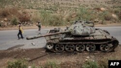 Des agriculteurs passent à côté d'un char abandonné le long de la route à Dansa, au sud-ouest de Mekele dans la région de Tigray, en Éthiopie, le 20 juin 2021 .