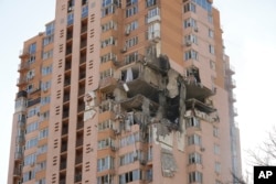 An apartment building damaged following a rocket attack on the city of Kyiv, Ukraine, Saturday, Feb. 26, 2022. Russian troops stormed toward Ukraine's capital Saturday, and street fighting broke out as city officials urged residents to take shelter. (AP Photo/Efrem Lukatsky)