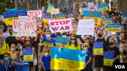 ប្រជាពលរដ្ឋ​អ៊ុយក្រែន កាន់បដា​ប្រឆាំង​សង្គ្រាម និង​ប្រធានាធិបតី​រុស្ស៊ី​លោក Vladimir Putin ក្នុង​អំឡុងពេល​ដើរ​ដង្ហែ​តាម​ដងផ្លូវ​ក្នុង​ទីក្រុង​បាងកក បន្ទាប់ពី​ការលុកលុយ​របស់​រុស្ស៊ី​ទៅលើ​អ៊ុយក្រែន ទីក្រុងបាងកក ប្រទេសថៃ ថ្ងៃទី២៧ ខែកុម្ភៈ ឆ្នាំ២០២២។ (Tommy Walker/វីអូអេ)