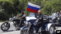 FILE - Russia's Prime Minister Vladimir Putin, foreground, rides a Harley-Davidson Lehman Trike 