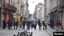 FILE - People queue at an ATM after Russian President Vladimir Putin authorized a military operation in eastern Ukraine, in Lviv, Ukraine, Feb. 24, 2022. 