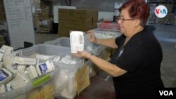 La voluntaria guatemalteca Marta Contreras ayuda en la recolección de insumos para los afectados por la guerra de Ucrania en el centro GEM de Miami, Florida. [Foto: Antoni Belchi / VOA]