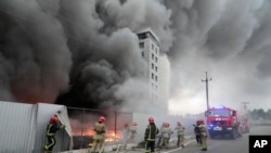 Firefighters work to extinguish a fire at a damaged logistic center after shelling in Kyiv, Ukraine, March 3, 2022.