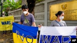 Protesters hold banners denouncing Russia's invasion of Ukraine in front of the Russian Embassy in Jakarta, Indonesia, March 4, 2022.