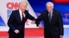 Bivši potpredsednik SAD Džozef Bajden i senator iz Vermonta Berni Sanders pozdravljaju se laktovima pred početak debate u studiju kablovske mreže CNN u Vašingtonu u nedelju 15. marta 2020. (Foto: AP/Evan Vucci)