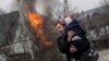 A man and a child escape from the town of Irpin, after heavy shelling on the only escape route used by locals, while Russian troops advance towards the capital of Kyiv, in Irpin, near Kyiv, Ukraine March 6, 2022. REUTERS/Carlos Barria