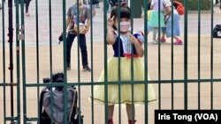 打扮成白雪公主的小女孩在香港迪士尼樂園大閘外等候入場。(美國之音/湯惠芸)