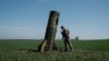 A Ukrainian serviceman looks at a Russian ballistic missile's booster stage that fell in a field in Bohodarove, eastern Ukraine, on April 25, 2022, amid the Russian invasion of Ukraine. 
