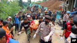 Rescuers carry the body of a victim recovered from under the rubble at a village affected by an earthquake-triggered landslide in Cianjur, West Java, Indonesia, Tuesday, Nov. 22, 2022. (AP Photo/Rangga Firmansyah)
