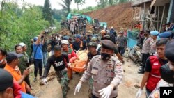 Spasioci nose telo žrtve nađeno ispod ruševina u selu u Cijandjuru u Zapadnoj Javi, 22. novembra 2022. 