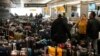 Travelers wade through unclaimed baggage near the Southwest Airlines baggage carousels at Denver International Airport, Dec. 27, 2022. 