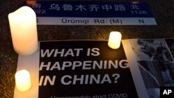 Posters and candles are seen during a gathering at Portsmouth Square in San Francisco, Tuesday, Nov. 29, 2022.