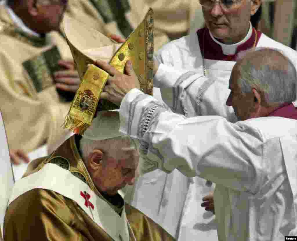 Colocan la mitra al papa Benedicto XVI cuando se dispone a pronunciar su misa inaugural en la Plaza de San Pedro del Vaticano, el 24 de abril de 2005.&nbsp;