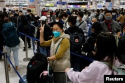 A woman celebrates at Hong Kong's Lok Ma Chau border checkpoint on the first day China reopens the border amid the coronavirus disease (COVID-19) pandemic in Hong Kong, China, Jan. 8, 2023.