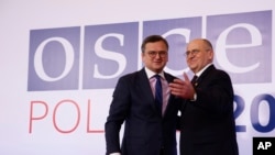 El Ministro de Relaciones Exteriores de Polonia, Zbigniew Rau, a la derecha, da la bienvenida a su homólogo ucraniano, Dmytro Kuleba, a la izquierda, durante una reunión de alto nivel de la Organización para la Seguridad y la Cooperación en Europa en Lodz, Polonia, el 1 de diciembre de 2022.