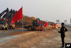 រូបឯកសារ៖ មន្ត្រីប៉ូលិសម្នាក់ឈរយាមការដ្ឋានសាងសង់ផ្លូវល្បឿនលឿនដំបូងរបស់កម្ពុជា ដែលឧបត្ថម្ភដោយចិន ក្នុងពិធីបើកសម្ពោធការដ្ឋាននេះ នៅខេត្តកំពង់ស្ពឺ កាលពីថ្ងៃទី ២២ ខែមីនា ឆ្នាំ ២០១៩។