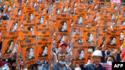 FILE - In this file photo taken on Feb. 28, 2021 protesters hold posters with the image of detained civilian leader Aung San Suu Kyi during a demonstration against the military coup in Naypyidaw, Myanmar.