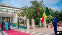 ARCHIVES - Un homme tient le drapeau sénégalais devant l'entrée du Parlement à Dakar, le 12 septembre 2022.