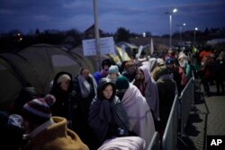 Refugees fleeing Russia's invasion of Ukraine queue at the Medyka border crossing, Poland, March 10, 2022. (AP Photo/Daniel Cole, File)