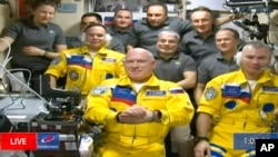 In this frame grab from video provided by Roscosmos, Russian cosmonauts Sergey Korsakov, Oleg Artemyev and Denis Matveyev are seen during a welcome ceremony after arriving at the International Space Station, March 18, 2022.