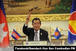 រូប​ឯកសារ៖ នាយករដ្ឋ​មន្ត្រី​កម្ពុជា​លោក ​ហ៊ុន​ សែន​ កាល​ពី​ថ្ងៃ​ព្រហស្បតិ៍​ ទី​២៨ ខែ​តុលា ឆ្នាំ​២០២១ បាន​ទទួល​ញញួរ​ប្រធាន​ប្តូរវេន​ សមាគម​ប្រជាជាតិ​អាស៊ីអាគ្នេយ៍​ (អាស៊ាន)​ ជា​លើក​ទី​៣ បន្ត​ពី​ប្រទេស​ព្រុយណេ​ដែល​បាន​បញ្ចប់​អាណត្តិ​របស់​ខ្លួននៅ​ឆ្នាំ​២០២១​នេះ។ (ហ្វេសប៊ុក/ទំព័រ​នាយករដ្ឋមន្ត្រី​ហ៊ុន សែន)