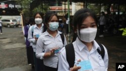 រូបឯកសារ៖ សិស្សវិទ្យាល័យបង្ហាញកាត់ចាក់វ៉ាក់សាំងបង្ការជំងឺកូវីដ១៩ នៅវិទ្យាល័យព្រះស៊ីសុវត្ថ រាជធានីភ្នំពេញ កាលពីថ្ងៃទី ១៥ ខែកញ្ញា ឆ្នាំ ២០២១។