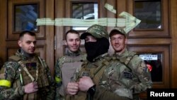 FILE - Four foreign fighters from the UK pose for a picture prior to their departure towards the front line in the east of Ukraine following the Russian invasion, at the main train station in Lviv, Ukraine, March 5, 2022. 