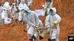 FILE - In this photo released by Xinhua News Agency, rescuers carry a piece of plane wreckage at the site of Monday's plane crash in Tengxian County, southern China's Guangxi Zhuang Autonomous Region, on March 25, 2022.