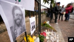 An image of Foo Fighters' drummer Taylor Hawkins adorns a makeshift memorial outside the hotel where Hawkins was found dead, in northern Bogota, Colombia, March 26, 2022. 