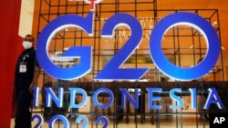 一名保安站在二十國聯合峰會峰的巨大招牌旁，二十國衛生和財政部長即將在印尼巴厘島參加這次峰會有關健康、可持續能源及數碼轉變加的討論，然而俄烏衝突、美中與西方國家日益緊張的關係或將始終是這次會議揮之不去的陰影。