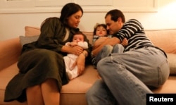 Noor Djait, 31, an architect, and Ismail Benmiled, 36, a businessman, pose for a photograph with their three-year-old son Said and four-month-old daughter Malek at their house in Tunis, Tunisia, Feb. 9, 2018.