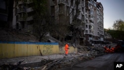 基輔志願者在情理被俄軍炮火摧毀的街道。