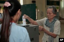 FILE - An elderly woman votes in local elections at a polling station in Takhmau in Kandal province, southeast of Phnom Penh, Cambodia, Sunday, June 4, 2017.
