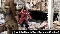 A child emerges from the Azovstal steel plant during UN-led evacuations after nearly two months of siege warfare on Mariupol, Ukraine, by Russia, in this still image from a video released May 1, 2022. Credit: David Arakhamia/Azov Regiment/Handout via REUT