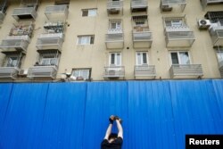 工人在北京市一个居民小区楼外竖起屏障进行封闭。（2022年4月29日）