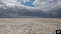 A man walks along Lake Tuz in Aksaray province, Turkey, Monday, Oct. 25, 2021. Lake Tuz, Turkey’s second largest lake, and home to several bird species has seen its waters entirely recede this year. (AP Photo/Emrah Gurel)