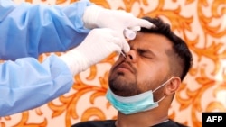 បុគ្គលិកពេទ្យម្នាក់កំពុងធ្វើតេស្តរកវីរុសកូរ៉ូណាលើពលរដ្ឋជនជាតិប៉ាគីស្ថានម្នាក់ នៅខេត្ត Karachi ប្រទេសប៉ាគីស្ថាន កាលពីថ្ងៃទី២១ ខែមេសា ឆ្នាំ២០២០។