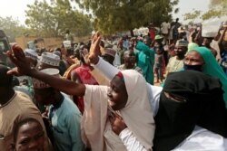 FILE - People gather to receive schoolboys who were rescued by the Nigerian security forces in Katsina, Nigeria, Dec. 18, 2020.
