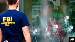 Anggota tim investigasi dari FBI tampak memeriksa lokasi kejadian perkara tempat berlangsung insiden penembakan di supermarket di Buffalo, New York, pada 16 Mei 2022. (Foto: AP/Matt Rourke)