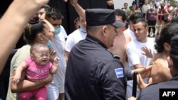 Las personas detenidas por presuntos vínculos con pandillas son escoltadas por la Policía Nacional Civil durante el estado de emergencia declarado por el gobierno salvadoreño en el centro penal de San Salvador, el 25 de abril de 2022.
