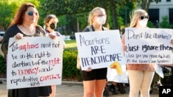 Women hold signs in support of abortion rights as they listen to speeches during a protest in support of legalized abortion at the Mississippi Capitol in Jackson, Miss., May 6, 2022. 