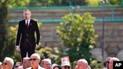 Un hombre sostiene una foto del presidente ruso Vladimir Putin durante la ceremonia del Día de la Victoria en Belgrado, Serbia, el 9 de mayo de 2022.