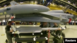 FILE - Technical sergeants of the German Air Force attach a new air-to-air missile IRIS-T (Infraread Imaging System - Tail/Thrust Vector Controlled) on a Eurofighter aircraft at the Fighter wing 73 airforce base in Laage, northern Germany, Dec. 5, 2005. 